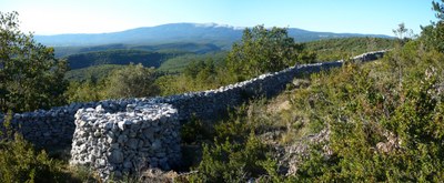 Il panorama che si apre sui monti del Vaucluse in direzione del Ventoux. In primo piano, una garitta davanti al muro della peste - Foto © Lacaille