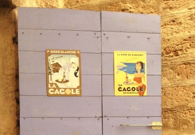 Vecchie pubblicità della birra La Cagole su una porta del Panier a Marsiglia